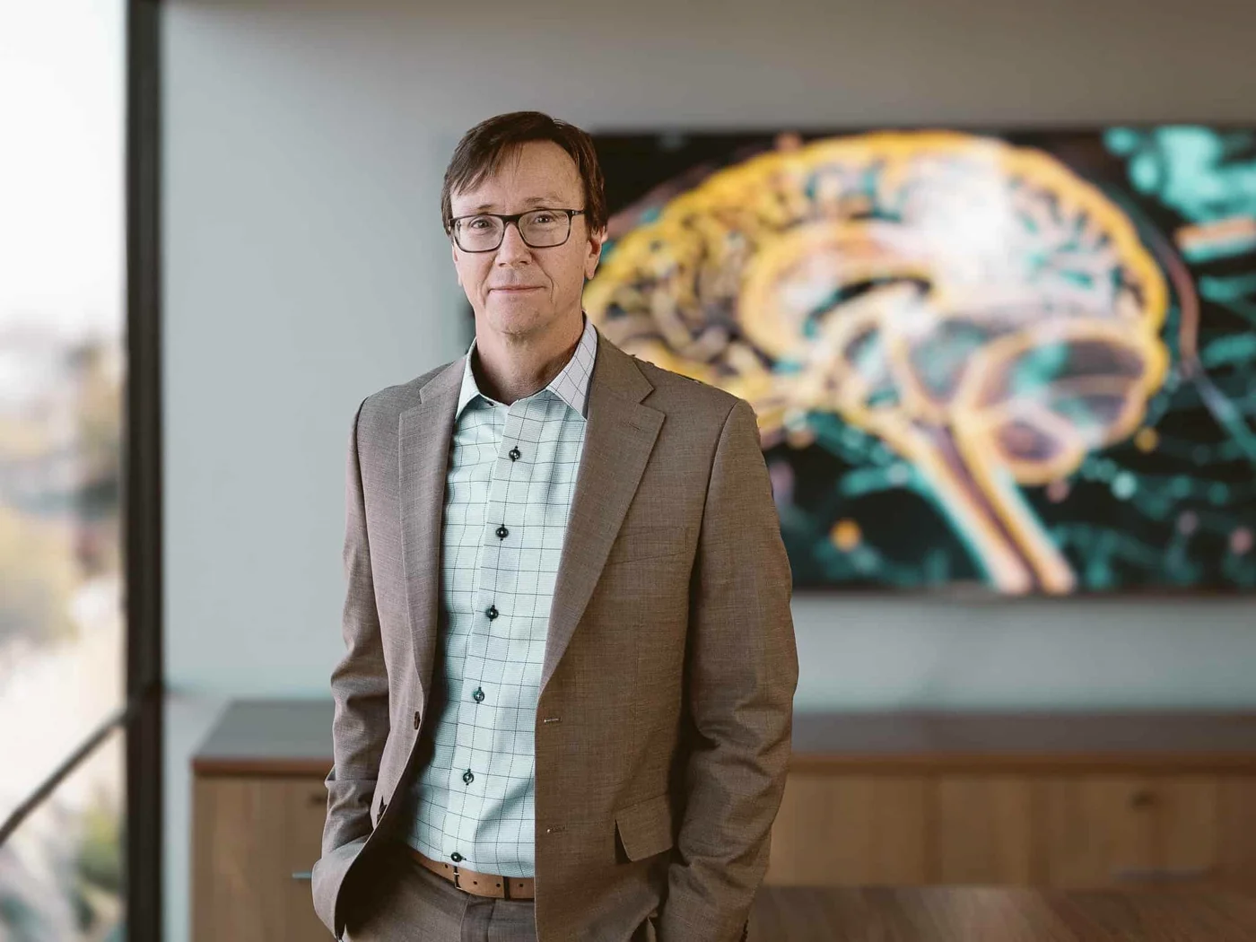 Vitanya co-founder and CEO Michael Southworth in the Vitanya office, standing in front of a brain-scan display